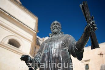 Malta'da bir parşömeni bulunan bir adamın heykeli